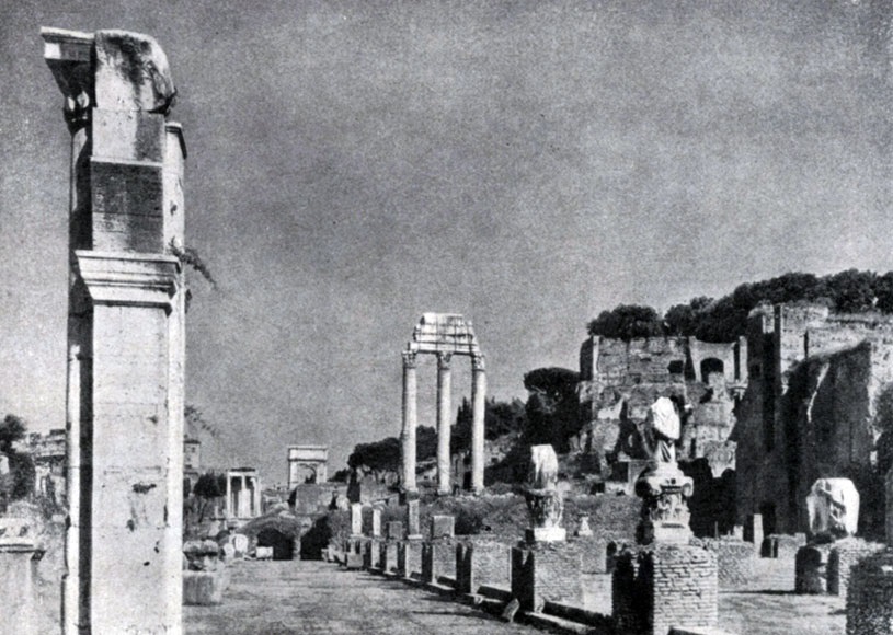 Римский форум (Форум Романум). На первом плане — базилика Юлия, далее в центре — три колонны храма Кастора и Поллукса, вдали арка Тита